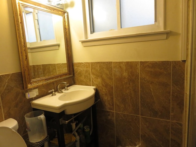 bathroom featuring vanity, tile walls, and toilet