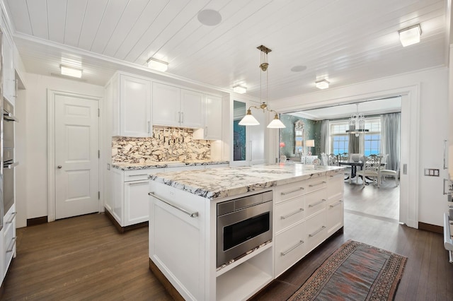 kitchen with light stone counters, decorative light fixtures, wooden ceiling, a center island, and white cabinetry