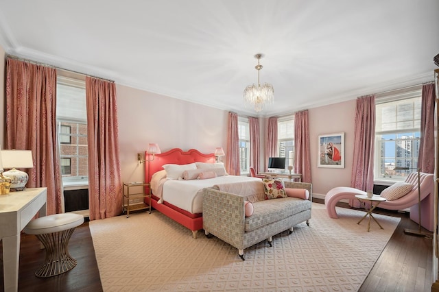 bedroom with crown molding, hardwood / wood-style floors, and a chandelier