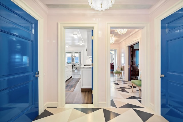 foyer with ornamental molding and a chandelier