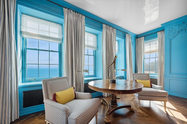 sitting room with dark parquet floors and ornamental molding