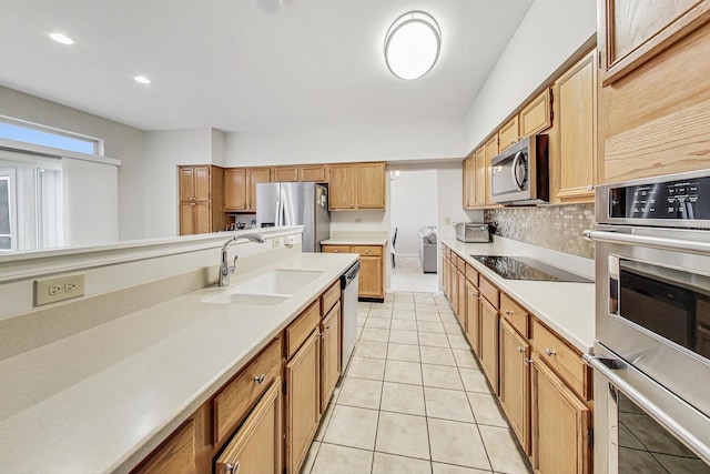 kitchen with light tile patterned floors, stainless steel appliances, tasteful backsplash, and sink