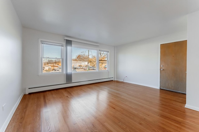 unfurnished room featuring a baseboard radiator and wood-type flooring