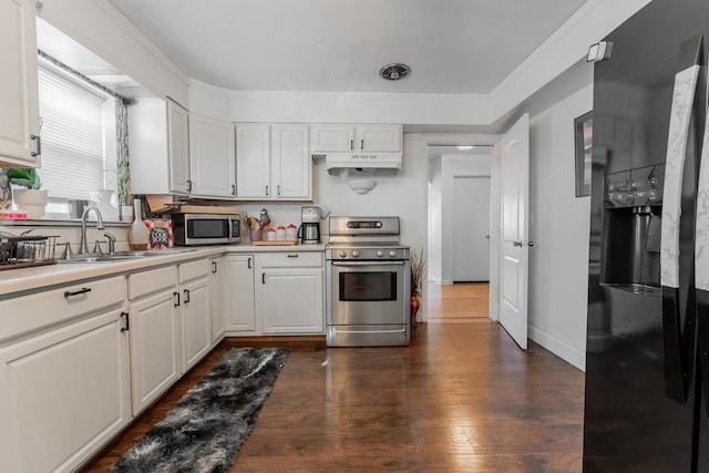 kitchen with stainless steel appliances, white cabinets, sink, and dark wood-type flooring