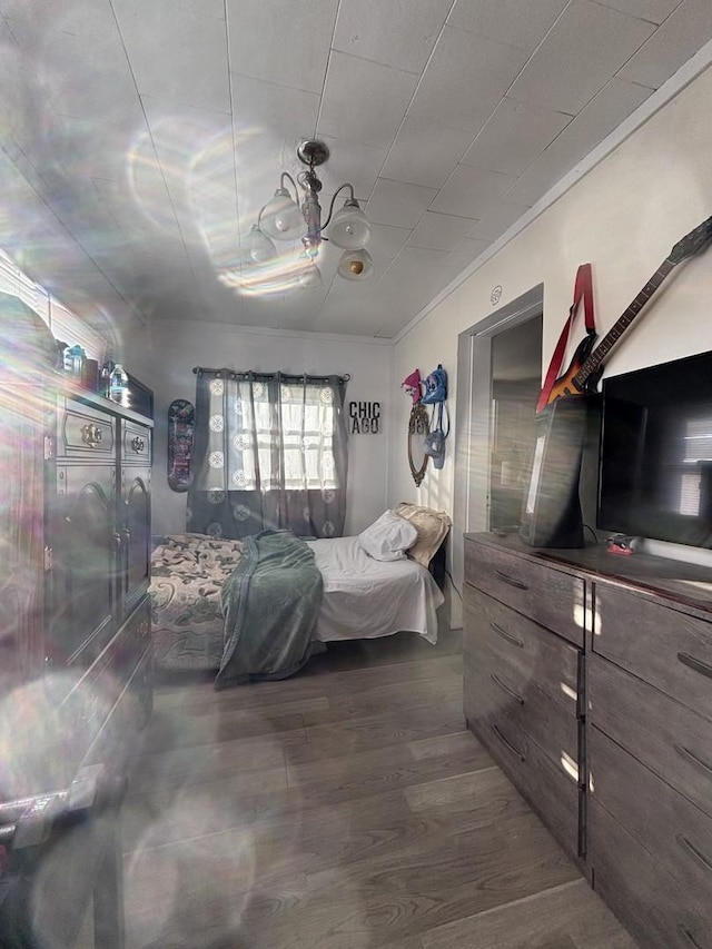 bedroom with ornamental molding and dark wood-type flooring