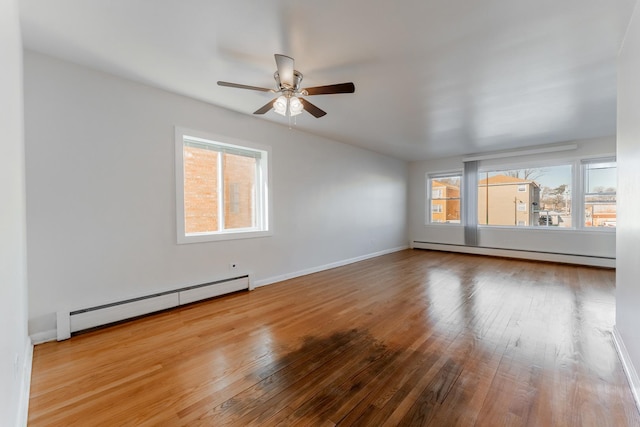 spare room featuring ceiling fan, a baseboard radiator, and wood-type flooring