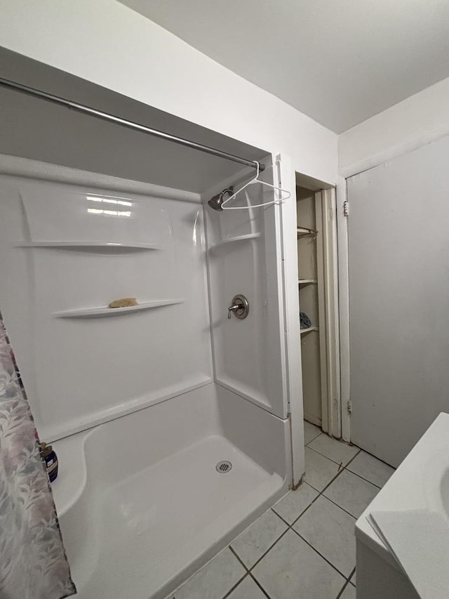 bathroom featuring curtained shower and tile patterned flooring