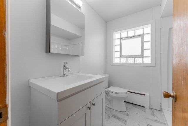 bathroom featuring toilet, vanity, and baseboard heating