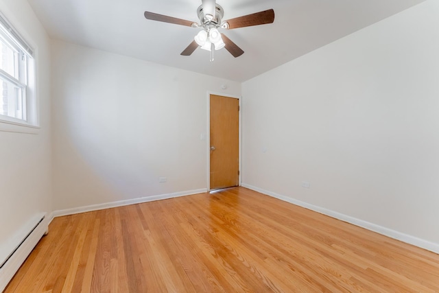 spare room featuring baseboard heating, ceiling fan, and light hardwood / wood-style floors