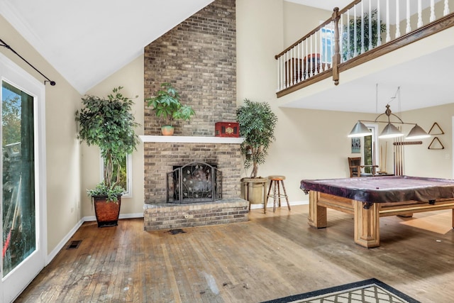 playroom featuring a fireplace, high vaulted ceiling, wood-type flooring, and billiards