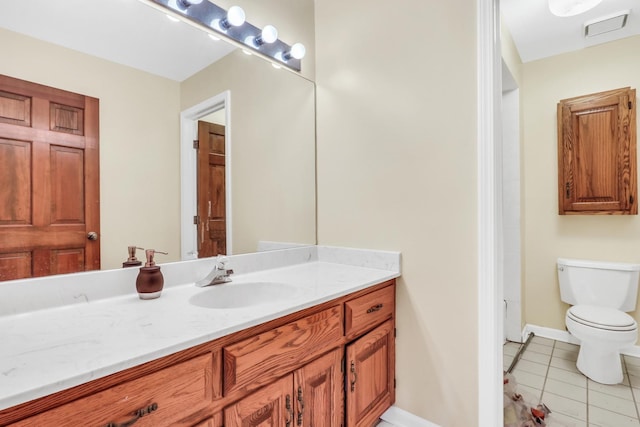 bathroom with tile patterned flooring, vanity, and toilet