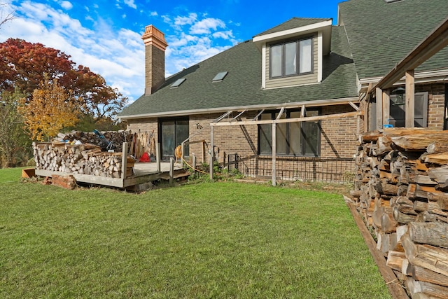 rear view of house featuring a deck and a yard