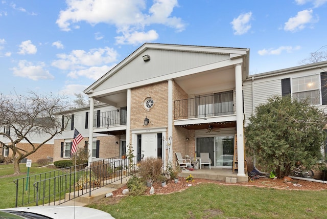 view of front of home with a balcony and a front yard