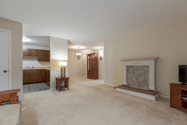 living room with sink, light carpet, and an inviting chandelier