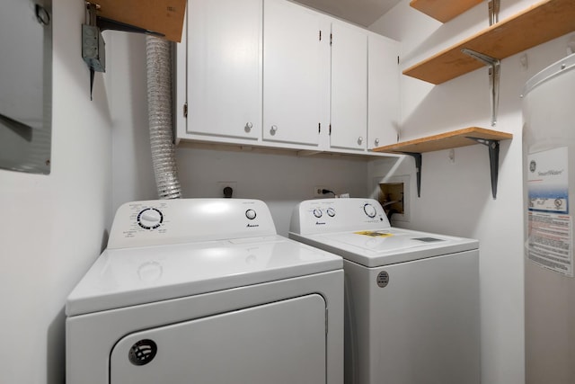 washroom featuring washing machine and clothes dryer, water heater, and cabinets