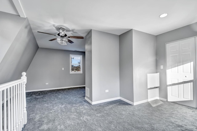 interior space with vaulted ceiling, dark carpet, and ceiling fan