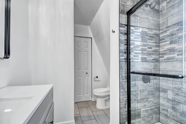 bathroom with vanity, toilet, and a shower with door