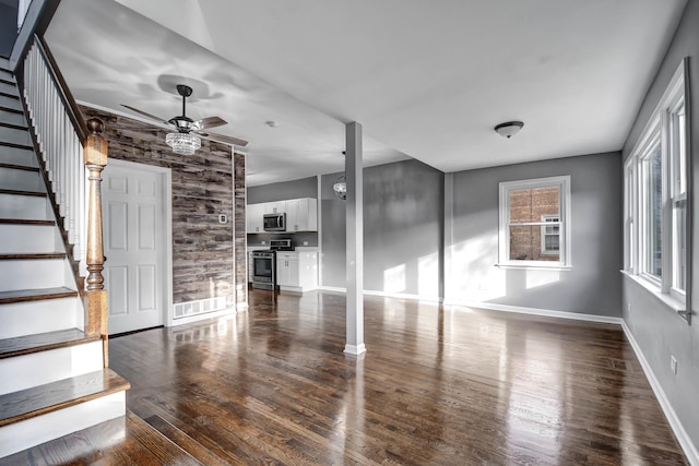 unfurnished living room with ceiling fan and dark hardwood / wood-style flooring