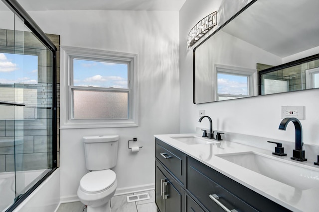 full bathroom featuring plenty of natural light, vanity, bath / shower combo with glass door, and toilet