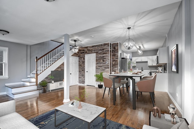 living room featuring dark hardwood / wood-style flooring and ceiling fan with notable chandelier