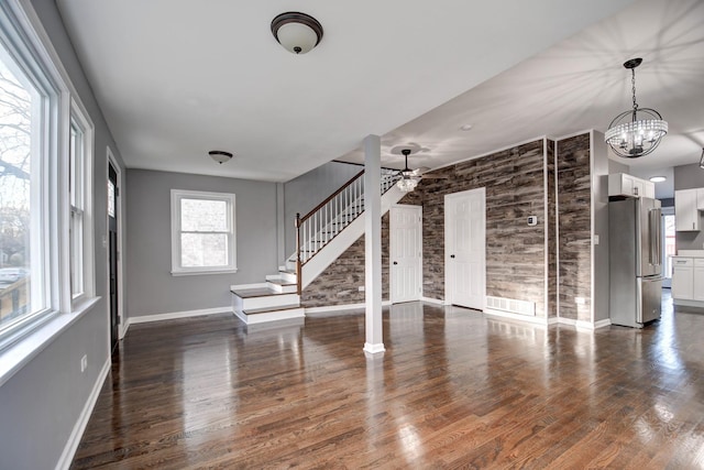 spare room featuring ceiling fan with notable chandelier and dark hardwood / wood-style flooring