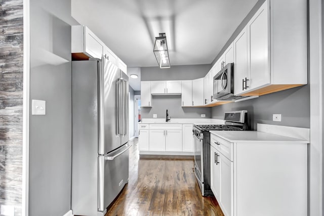 kitchen with dark hardwood / wood-style floors, sink, white cabinetry, and stainless steel appliances