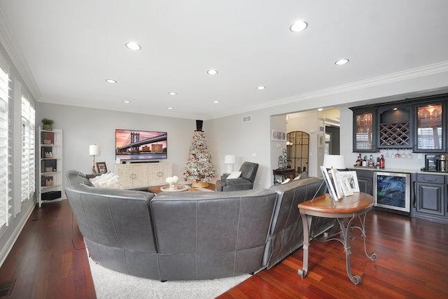 living room featuring dark wood-type flooring, crown molding, bar, and beverage cooler