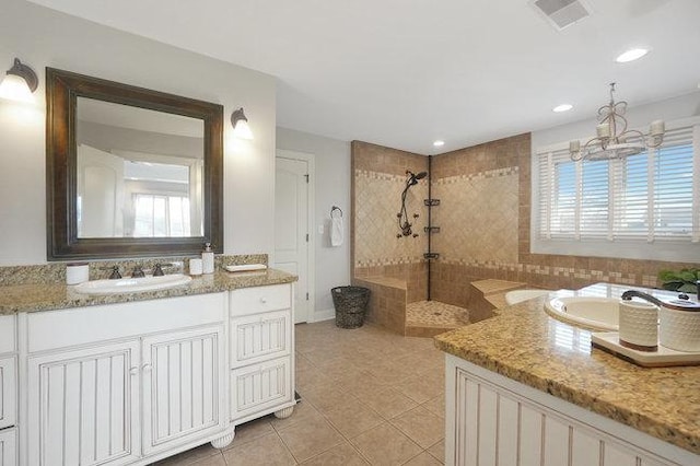 bathroom featuring a tile shower, vanity, tile patterned floors, and a notable chandelier