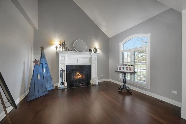 unfurnished living room featuring high vaulted ceiling and dark hardwood / wood-style floors