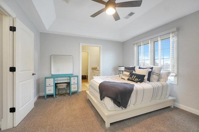 bedroom with a tray ceiling, connected bathroom, ceiling fan, and carpet flooring