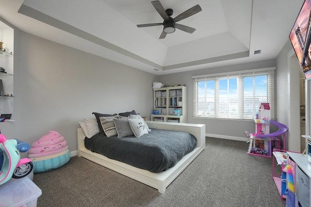 bedroom featuring carpet flooring, a raised ceiling, and ceiling fan