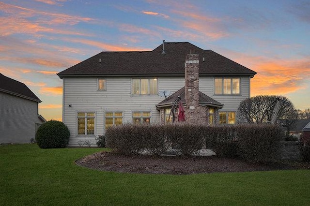 back house at dusk with a yard