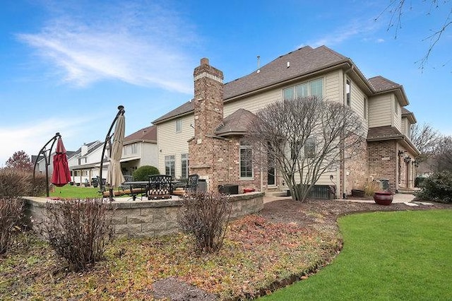 rear view of house with a yard and a patio