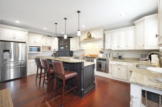 kitchen featuring white cabinets, sink, a kitchen island, and appliances with stainless steel finishes