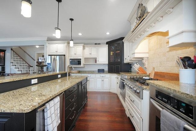 kitchen featuring pendant lighting, white cabinetry, sink, and stainless steel appliances