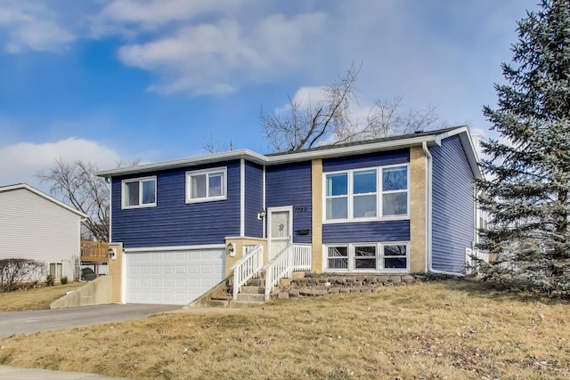 raised ranch with a garage and a front yard