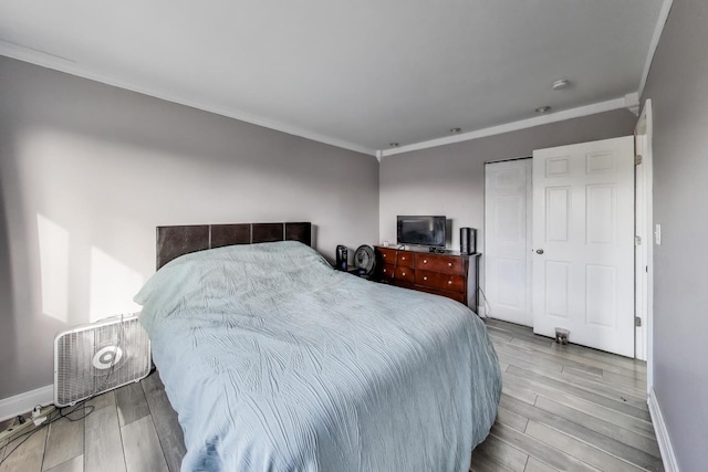 bedroom with light hardwood / wood-style floors, a closet, and ornamental molding