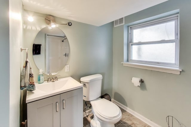 bathroom with vanity, toilet, a shower, and tile patterned floors