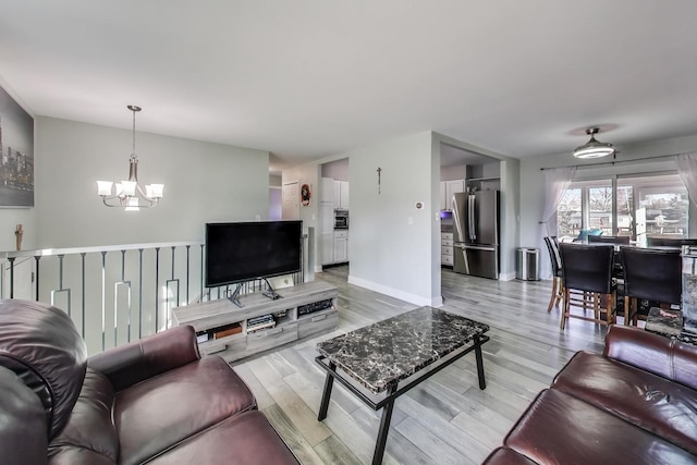 living room with an inviting chandelier and light hardwood / wood-style floors