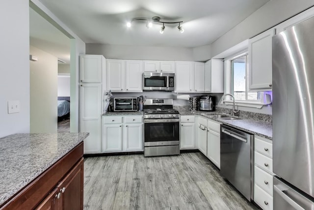 kitchen featuring light hardwood / wood-style floors, sink, white cabinets, and stainless steel appliances