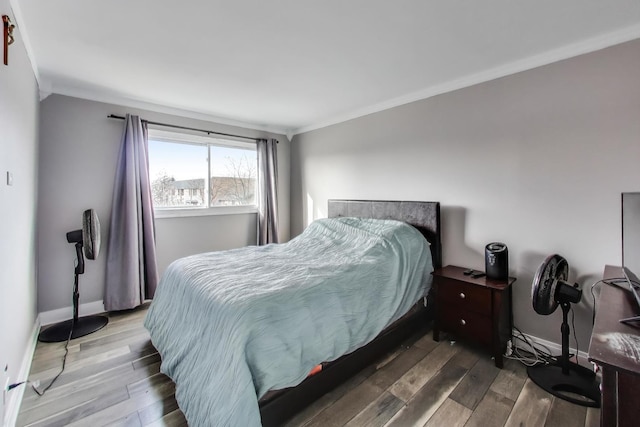 bedroom with hardwood / wood-style flooring and crown molding