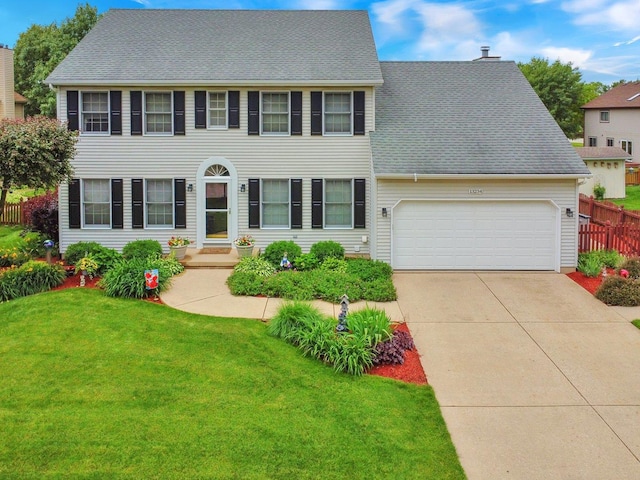 colonial inspired home with a garage and a front yard