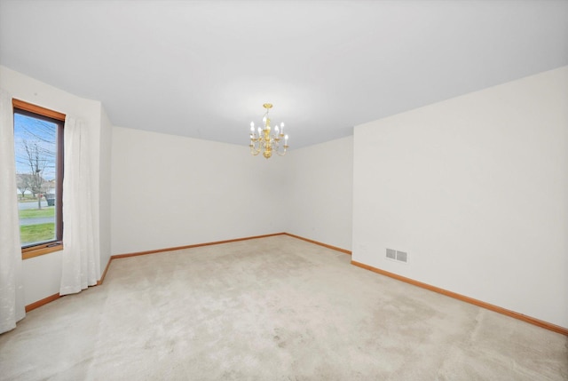 carpeted spare room with a notable chandelier