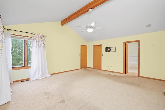 empty room featuring lofted ceiling with beams, carpet floors, and ceiling fan