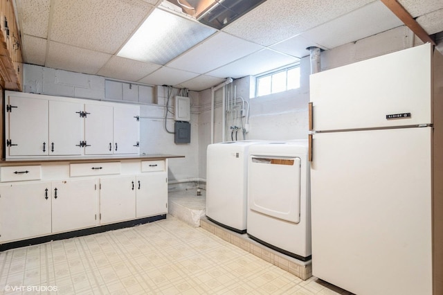 laundry room featuring separate washer and dryer, electric panel, and cabinets