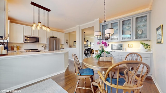 dining room featuring dark hardwood / wood-style flooring, crown molding, and sink