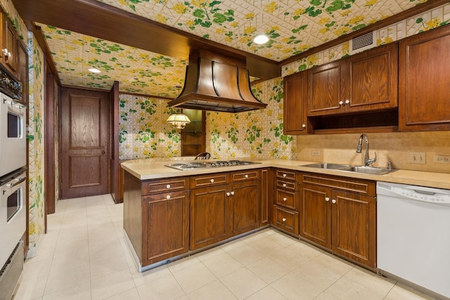 kitchen with kitchen peninsula, custom range hood, sink, dishwasher, and hanging light fixtures