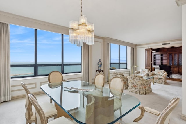 dining space featuring a chandelier, a water view, and plenty of natural light