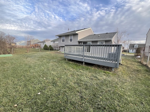 rear view of house with a yard and a wooden deck