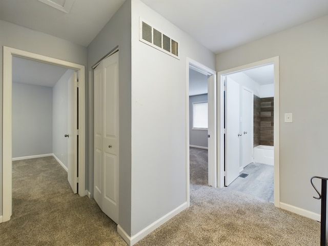 hallway featuring light colored carpet